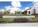 Community clubhouse with white brick, immaculate landscaping, and manicured lawn at 15708 Oakleaf Run Dr, Lithia, FL 33547