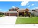 Beautiful two-story home featuring a three-car garage and manicured lawn at 15708 Oakleaf Run Dr, Lithia, FL 33547