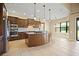Modern kitchen features a large island, stainless steel appliances, and an adjacent seating area at 15708 Oakleaf Run Dr, Lithia, FL 33547