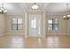 Large living room featuring tile floors, a decorative front door, and stylish chandeliers at 15708 Oakleaf Run Dr, Lithia, FL 33547