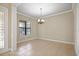 Neutral living room boasting tile floors, a decorative chandelier, and a front door view at 15708 Oakleaf Run Dr, Lithia, FL 33547