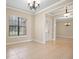 Open concept living room features tile floors, a decorative chandelier, and natural light at 15708 Oakleaf Run Dr, Lithia, FL 33547