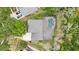 Aerial view of a home with a gray roof, large trees, and a private pool and spa at 15912 Ternglade Dr, Lithia, FL 33547