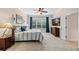 Bright bedroom with ceiling fan, blue curtains, a large window, and a comfortable queen-sized bed at 15912 Ternglade Dr, Lithia, FL 33547