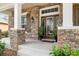 Detailed view of the front entrance featuring a stone facade, sidelights, and elegant plants at 15912 Ternglade Dr, Lithia, FL 33547