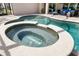 Sunlit spa and pool with clear water, surrounded by a brick-tile deck and lush landscaping at 15912 Ternglade Dr, Lithia, FL 33547