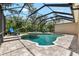 The backyard features a screened-in pool with a spa and plenty of space for lounging and relaxing at 15912 Ternglade Dr, Lithia, FL 33547