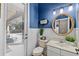 Elegant powder room with blue accent wall, white wainscoting, and charming rope mirror at 15912 Ternglade Dr, Lithia, FL 33547