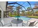 Relaxing screened-in pool area with table, chairs, and refreshing pool view and tiled pool features at 16 Hibiscus Rd, Belleair, FL 33756