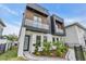Stylish two-story home showcasing a landscaped front yard, a black wrought iron fence and a modern exterior at 1627 9Th N Ave, St Petersburg, FL 33713