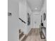Bright hallway featuring light wood floors, modern art, and a sleek console table, leading to a staircase at 1627 9Th N Ave, St Petersburg, FL 33713
