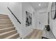 Hallway with wooden stairs, minimalist artwork, and a console table, creating an inviting and modern entryway at 1627 9Th N Ave, St Petersburg, FL 33713