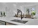 Kitchen island featuring quartz countertops with modern sink and faucet, seamlessly blending into the open living space at 1627 9Th N Ave, St Petersburg, FL 33713