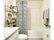 A bright bathroom features a shower and tub, complemented by a stylish vanity and storage shelving at 17014 Oval Rum Dr, Wimauma, FL 33598