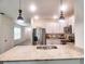 Open-concept kitchen featuring granite counters, stainless appliances, and barstool seating at 17014 Oval Rum Dr, Wimauma, FL 33598