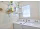 Bright laundry room featuring modern appliances, a window, and shelving at 17014 Oval Rum Dr, Wimauma, FL 33598