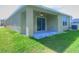 View of the covered patio, sliding glass doors, and lawn at 17014 Oval Rum Dr, Wimauma, FL 33598
