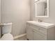 This half-bath features a classic toilet, grey vanity and a bright mirror with modern fixtures at 1844 Bough Ave # C, Clearwater, FL 33760