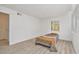 Bright bedroom with wood-look floors, a window with blinds, and a simple bed at 1844 Bough Ave # C, Clearwater, FL 33760