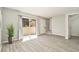 Neutral living room featuring wood-look floors, a sliding glass door with curtains, and a staircase nearby at 1844 Bough Ave # C, Clearwater, FL 33760