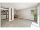 Bright living room with gray wood-look floors, a dining nook, and a kitchen featuring stainless steel appliances at 1844 Bough Ave # C, Clearwater, FL 33760