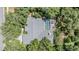 Aerial view showcasing the home with a screened pool surrounded by mature trees at 18806 Autumn Lake Blvd, Hudson, FL 34667
