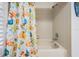 Clean bathroom featuring a shower-tub combo with colorful, patterned shower curtain, and a tiled shower at 18806 Autumn Lake Blvd, Hudson, FL 34667