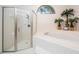 Clean bathroom with a separate shower and bathtub, a window and tropical plants at 18806 Autumn Lake Blvd, Hudson, FL 34667