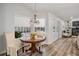 Bright breakfast nook featuring a chandelier, round wooden table, and views of the backyard pool area at 18806 Autumn Lake Blvd, Hudson, FL 34667