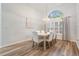 Dining room featuring a modern chandelier, big window with shutters and hardwood floors at 18806 Autumn Lake Blvd, Hudson, FL 34667