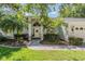 Charming home exterior with a welcoming front entrance, green lawn, and lovely landscaping at 18806 Autumn Lake Blvd, Hudson, FL 34667