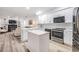 Modern kitchen with stainless steel appliances, quartz countertops, white cabinets, and open floor plan at 18806 Autumn Lake Blvd, Hudson, FL 34667
