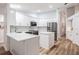 Bright, fully-equipped kitchen with stainless steel appliances, white cabinetry and an island at 18806 Autumn Lake Blvd, Hudson, FL 34667