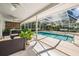 Screened-in pool with ceiling fans, a lounge area, and tranquil backyard views at 18806 Autumn Lake Blvd, Hudson, FL 34667