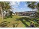 Lush backyard featuring a screened-in pool area, mature trees, and well-maintained lawn, perfect for outdoor enjoyment at 20191 Rutherford Ave, Port Charlotte, FL 33952