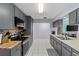 Well-equipped kitchen with stainless steel appliances, gray cabinets, and tile backsplash at 20191 Rutherford Ave, Port Charlotte, FL 33952