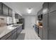 Bright kitchen features gray cabinets, stainless steel appliances, and tile flooring at 20191 Rutherford Ave, Port Charlotte, FL 33952