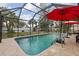 Enclosed in-ground pool with outdoor privacy and tropical landscaping at 20191 Rutherford Ave, Port Charlotte, FL 33952