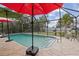 Inground pool with patio, umbrellas, landscaping, and privacy at 20191 Rutherford Ave, Port Charlotte, FL 33952