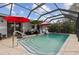 Screen-enclosed pool with stone patio, multiple umbrellas and privacy at 20191 Rutherford Ave, Port Charlotte, FL 33952