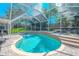 Backyard pool with screened enclosure, complemented by lush landscaping and a spacious patio area at 230 Gray Oak Dr, Tarpon Springs, FL 34689