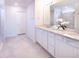 Bright bathroom featuring double sinks, white cabinets and a shower at 29922 Marquette Ave, Wesley Chapel, FL 33545