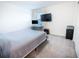 Minimalist bedroom featuring a bed, computer desk, and mounted TV for a modern and functional space at 29922 Marquette Ave, Wesley Chapel, FL 33545