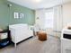 Cozy Bedroom with a white crib, rocking chair, and decorative animal prints at 29922 Marquette Ave, Wesley Chapel, FL 33545
