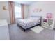 Bright bedroom with a plush bed, decorative wall art, and natural light streaming through the window at 29922 Marquette Ave, Wesley Chapel, FL 33545