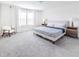 Bright bedroom with a light colored chair, large window and carpeted floors at 29922 Marquette Ave, Wesley Chapel, FL 33545