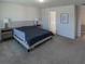 Bright bedroom with a queen bed, neutral walls, carpet floors, and views into the ensuite bathroom at 29922 Marquette Ave, Wesley Chapel, FL 33545