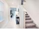 Bright foyer with tiled floor, staircase, and stylish console table at 29922 Marquette Ave, Wesley Chapel, FL 33545