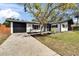 Charming home with black and white exterior and concrete driveway leading up to the garage at 2999 67Th S Ave, St Petersburg, FL 33712