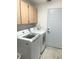 Well-equipped laundry room features a new washer and dryer and ample cabinet space at 3843 Tarpon Pointe Cir, Palm Harbor, FL 34684